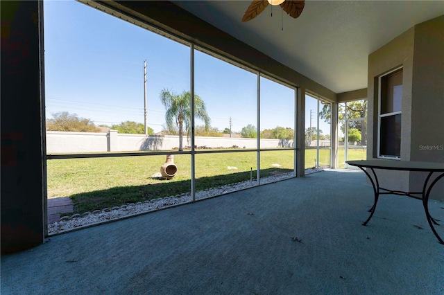 unfurnished sunroom with a wealth of natural light and ceiling fan
