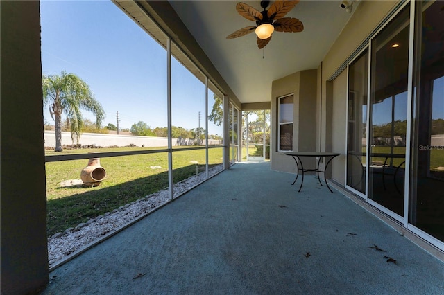 unfurnished sunroom featuring a ceiling fan