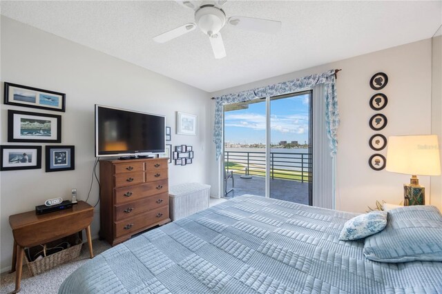 8020 Sailboat Key Blvd S Unit 101, St Pete Beach, FL 33707 - carpeted bedroom featuring access to exterior, a ceiling fan, and a textured ceiling