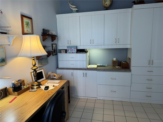 8020 Sailboat Key Blvd S Unit 101, St Pete Beach, FL 33707 - kitchen with light tile patterned floors, white cabinetry, and an office area