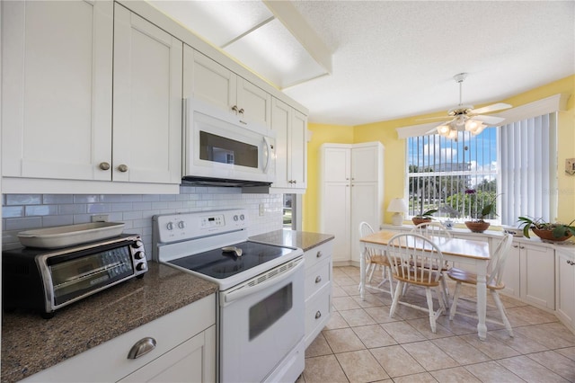 8020 Sailboat Key Blvd S Unit 101, St Pete Beach, FL 33707 - kitchen with white appliances, tasteful backsplash, white cabinets, and light tile patterned flooring