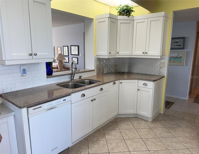 8020 Sailboat Key Blvd S Unit 101, St Pete Beach, FL 33707 - kitchen with white dishwasher, a sink, light tile patterned floors, and white cabinetry