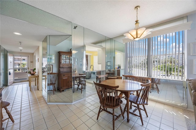 8020 Sailboat Key Blvd S Unit 101, St Pete Beach, FL 33707 - dining space with light tile patterned floors, a chandelier, and a textured ceiling