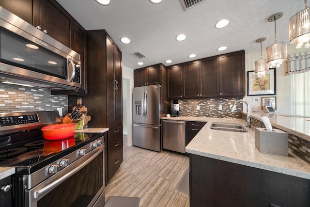 4544 Harbor Hills Dr, Largo, FL 33770 - kitchen with a sink, light stone countertops, appliances with stainless steel finishes, visible vents, and dark brown cabinets