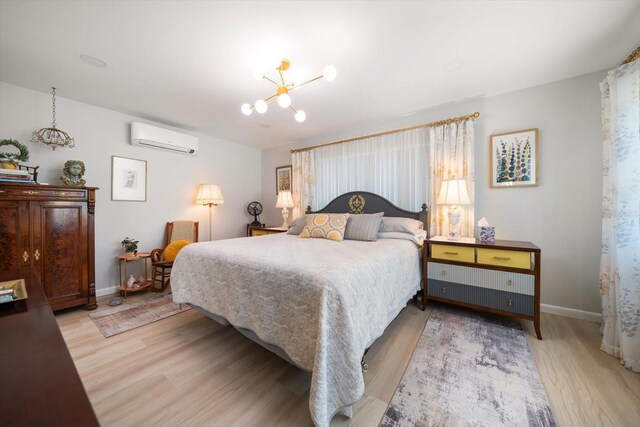 4544 Harbor Hills Dr, Largo, FL 33770 - bedroom featuring baseboards, light wood-type flooring, a wall mounted AC, and a notable chandelier
