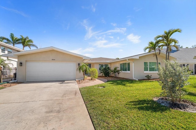 4544 Harbor Hills Dr, Largo, FL 33770 - single story home featuring concrete driveway, stucco siding, fence, an attached garage, and a front lawn