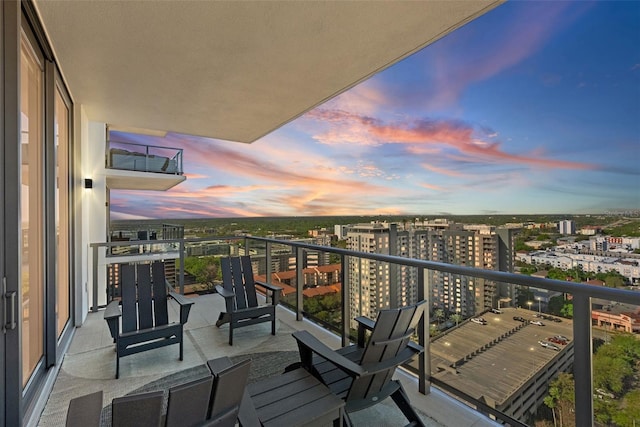 balcony at dusk featuring a city view