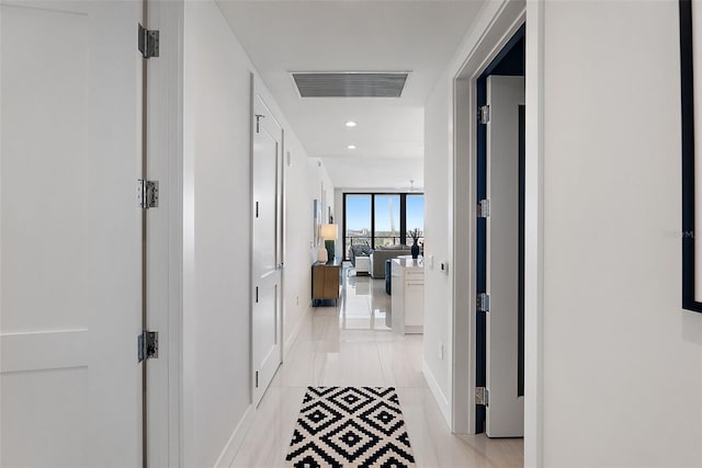 corridor with baseboards, visible vents, and recessed lighting