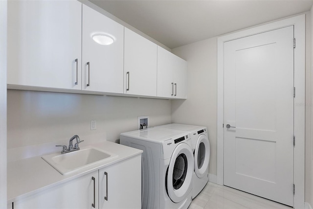 washroom featuring a sink, cabinet space, and washer and dryer