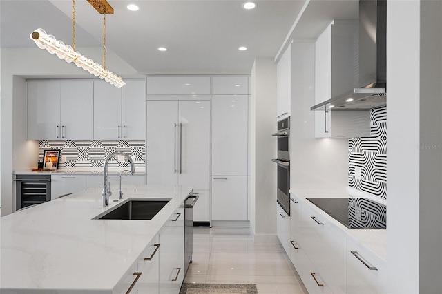 kitchen with white cabinets, modern cabinets, wine cooler, wall chimney exhaust hood, and a sink
