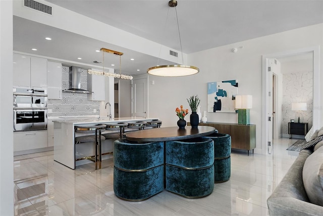 interior space featuring modern cabinets, visible vents, double oven, and white cabinets