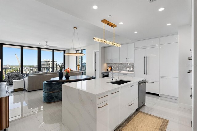 kitchen featuring a sink, paneled built in refrigerator, modern cabinets, decorative light fixtures, and decorative backsplash