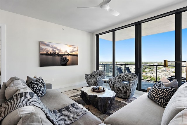 living area featuring baseboards, floor to ceiling windows, and a ceiling fan