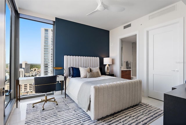 bedroom with floor to ceiling windows, light tile patterned floors, connected bathroom, and visible vents