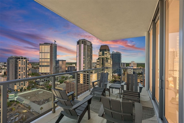 balcony at dusk featuring a city view