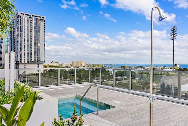 view of swimming pool featuring a hot tub and a city view