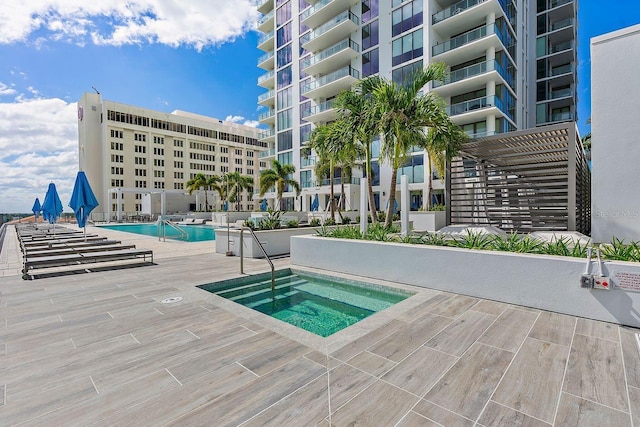 pool featuring a hot tub and a patio area