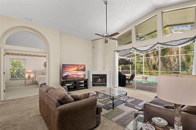 15014 Arbor Hollow Dr, Odessa, FL 33556 - living room featuring carpet floors, ceiling fan, lofted ceiling, and a lit fireplace