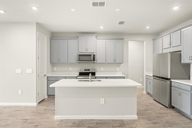 12323 Hearts Ease St, Venice, FL 34293 - kitchen featuring stainless steel appliances, visible vents, light wood-type flooring, and gray cabinets