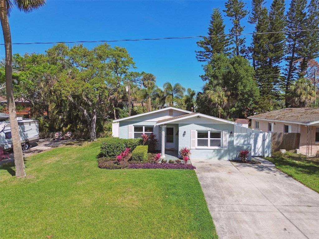 1775 Michigan Ave NE, Saint Petersburg, FL 33703 - view of front facade featuring driveway, fence, and a front yard