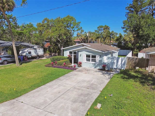 view of front of house with fence, concrete driveway, and a front yard