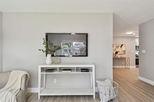 room details featuring baseboards, wood finished floors, range, and stainless steel microwave