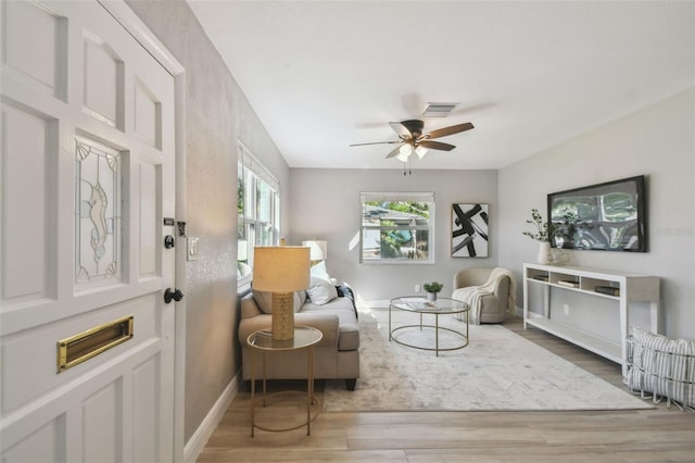 sitting room featuring a ceiling fan, baseboards, and wood finished floors