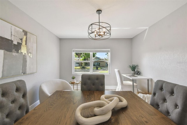 dining space featuring baseboards, a chandelier, and wood finished floors