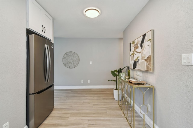 hallway with baseboards and light wood-style flooring