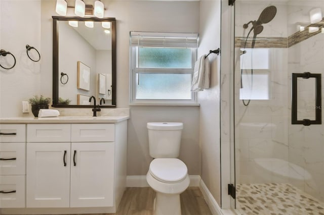 full bathroom featuring vanity, a marble finish shower, toilet, baseboards, and wood finished floors
