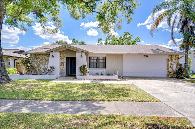 4110 Summerdale Dr, Tampa, FL 33624 - view of front of house with driveway, a front yard, an attached garage, and stone siding