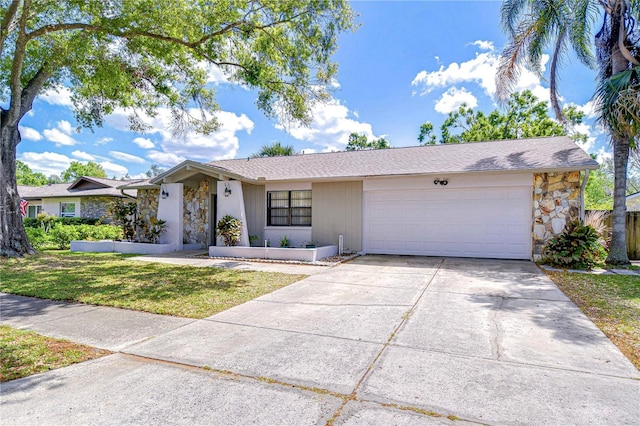 4110 Summerdale Dr, Tampa, FL 33624 - ranch-style home with stone siding, driveway, an attached garage, and a front yard