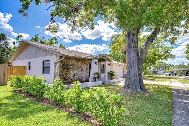 4110 Summerdale Dr, Tampa, FL 33624 - view of front of property featuring stone siding, concrete driveway, fence, an attached garage, and a front lawn