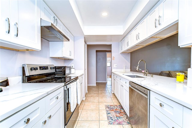 4110 Summerdale Dr, Tampa, FL 33624 - kitchen featuring a sink, white cabinetry, appliances with stainless steel finishes, under cabinet range hood, and light tile patterned floors