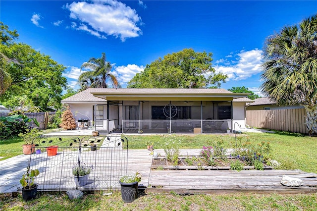 4110 Summerdale Dr, Tampa, FL 33624 - back of property with a fenced backyard, a lawn, stucco siding, and a sunroom