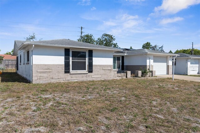 ranch-style house featuring stucco siding, a front yard, concrete driveway, and a garage