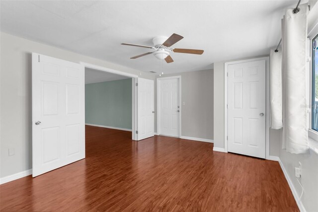 empty room with a ceiling fan, baseboards, and wood finished floors