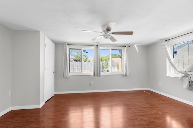unfurnished room featuring a ceiling fan, baseboards, and wood finished floors