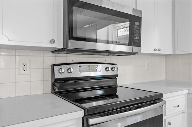 kitchen featuring white cabinets, light countertops, appliances with stainless steel finishes, and backsplash