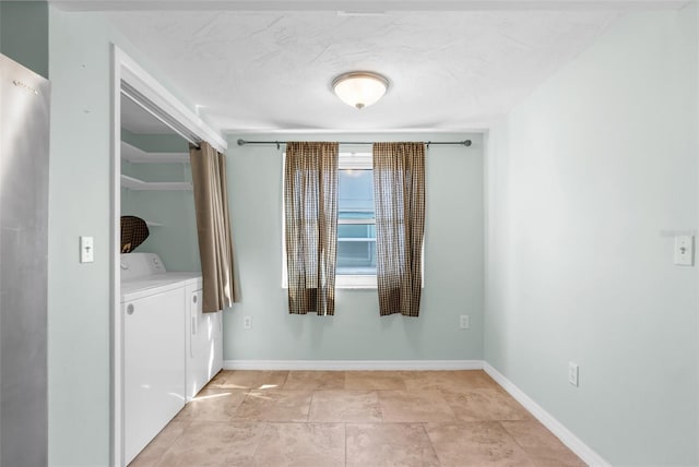 unfurnished room featuring baseboards and independent washer and dryer