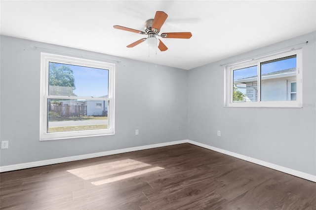 spare room with baseboards and wood finished floors