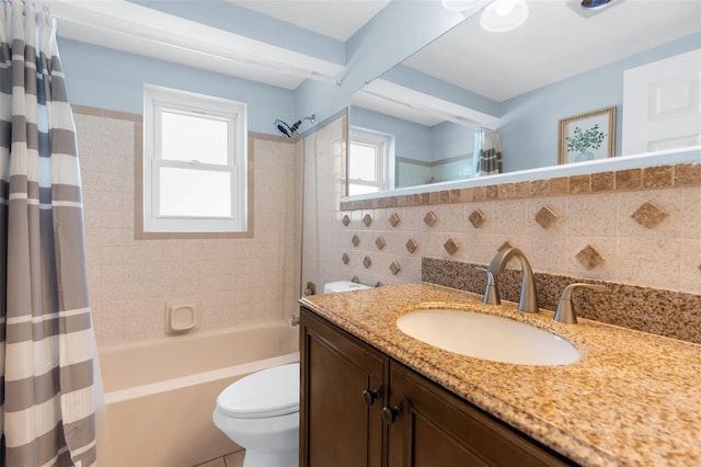 bathroom featuring toilet, shower / bath combo with shower curtain, tile walls, and vanity