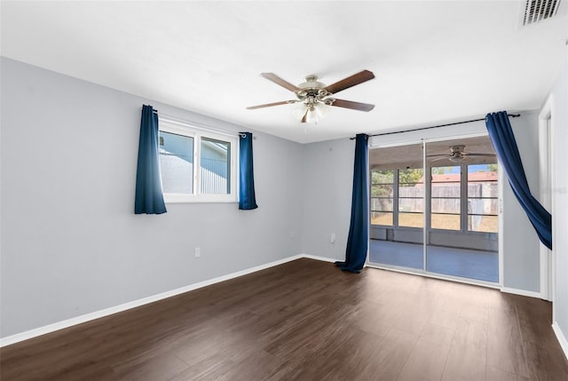 empty room with dark wood finished floors, baseboards, visible vents, and a ceiling fan