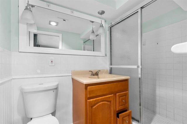 full bathroom featuring toilet, vanity, and a shower stall