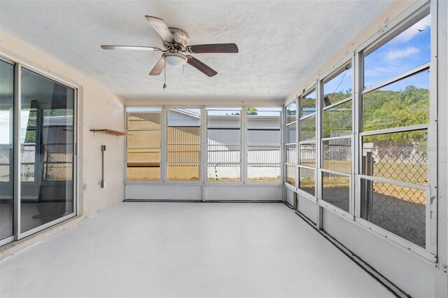 unfurnished sunroom featuring ceiling fan