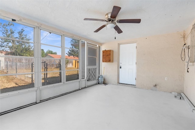 unfurnished sunroom featuring ceiling fan