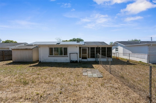rear view of house with a fenced backyard, a sunroom, and a yard