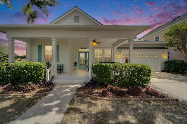 view of front of property featuring driveway, an attached garage, and a porch