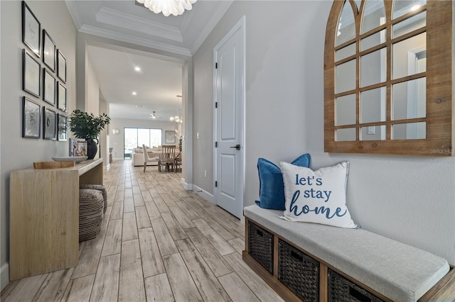 hall with crown molding, wood finish floors, baseboards, recessed lighting, and an inviting chandelier