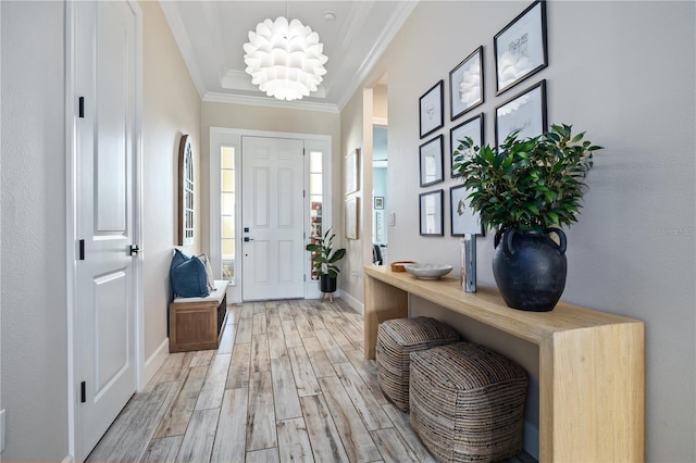 foyer featuring baseboards, light wood-style flooring, and ornamental molding